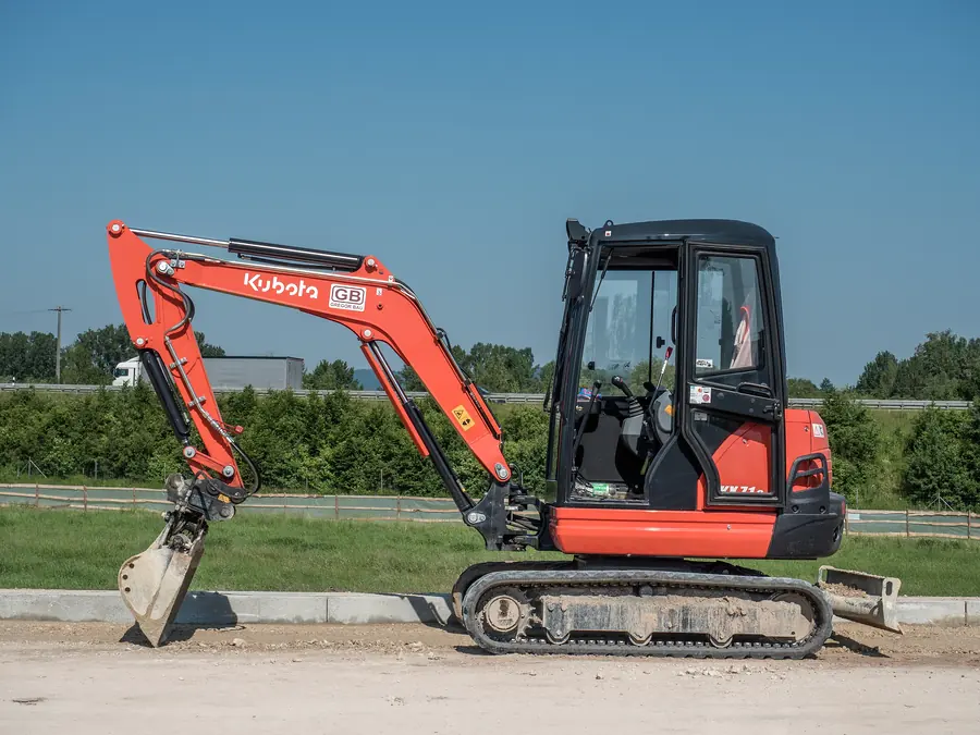Oranje Kubota-minigraver op een werkterrein
