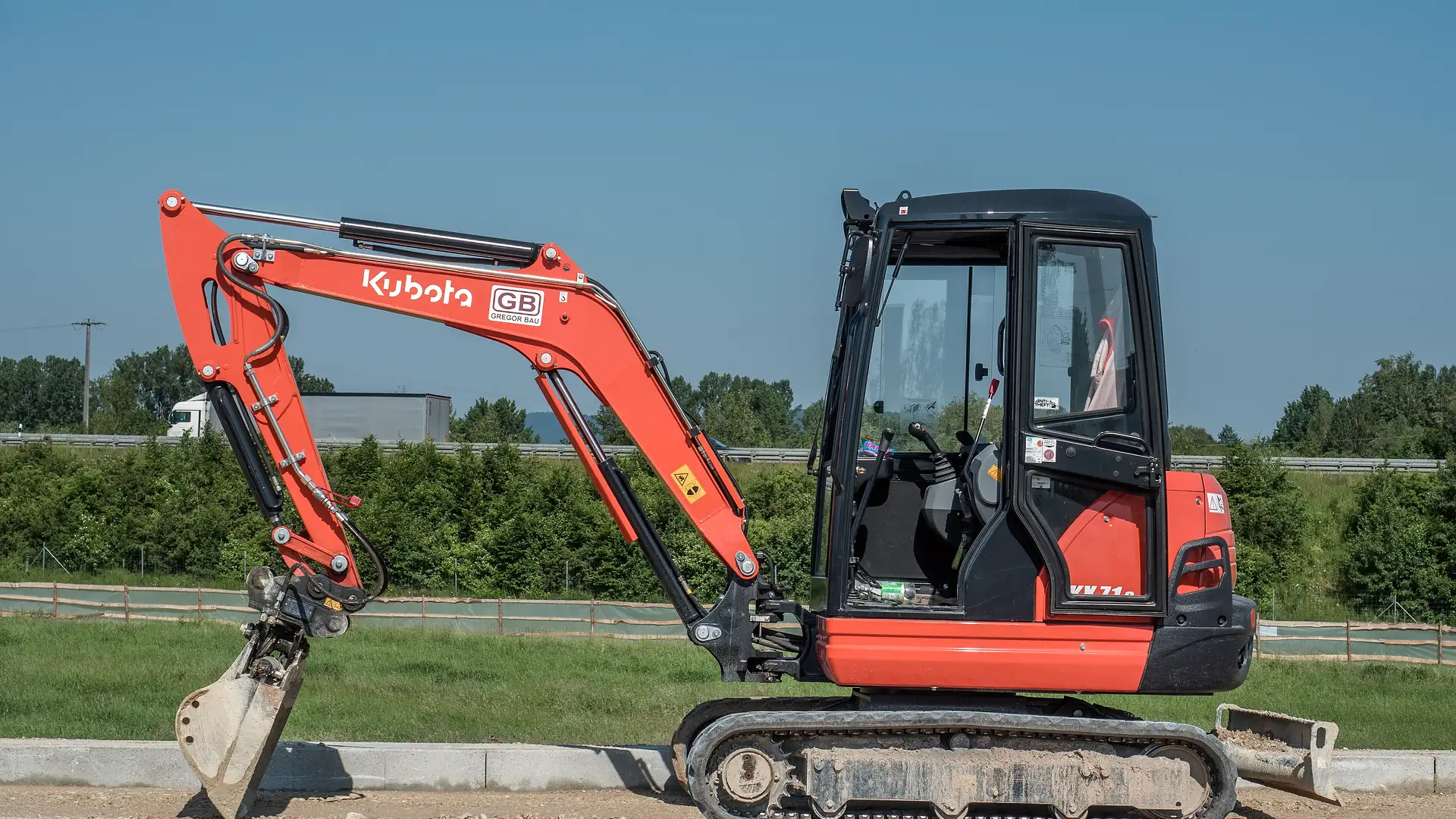 Oranje Kubota-minigraver op een werkterrein